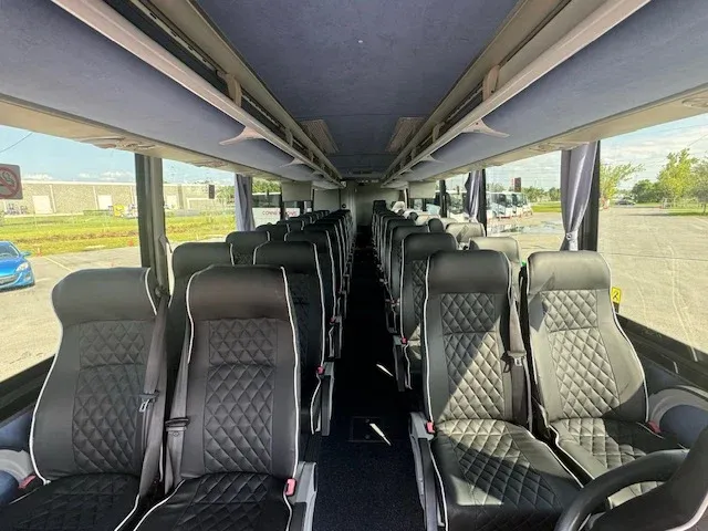 40 Passenger Charter Bus cabin view with window shades and overhead parcel racks