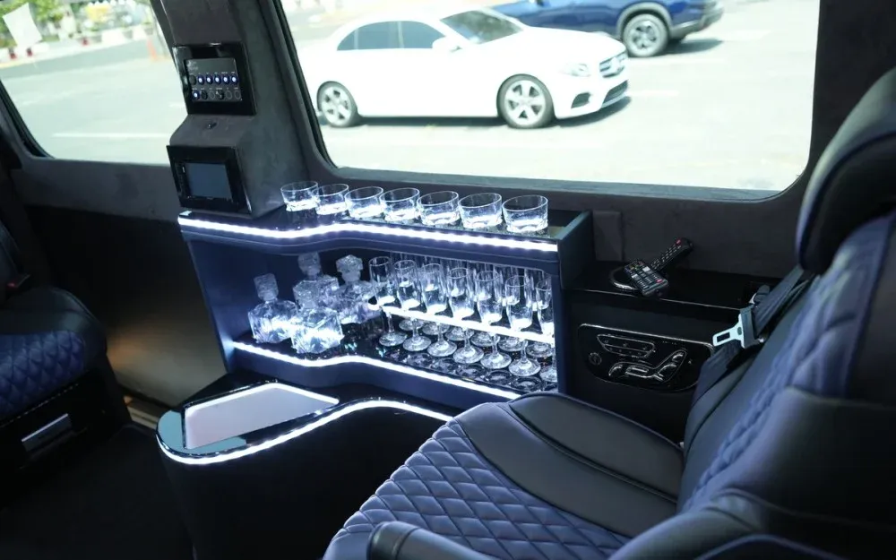 8 Passenger Executive Sprinter Shuttle Van cabin view with captain's chairs, LED accent lighting and bar area