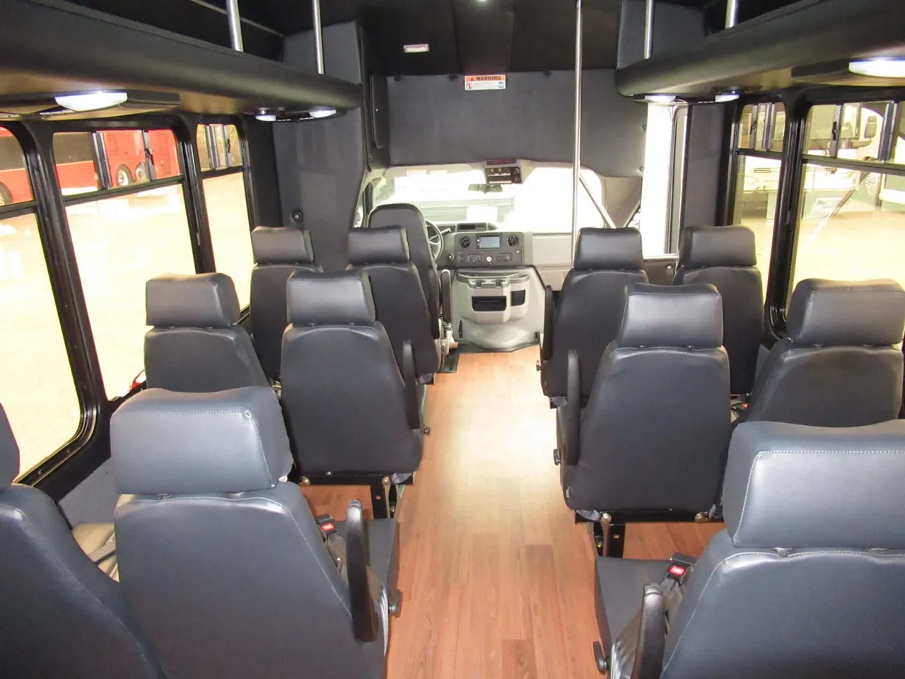 24 Passenger Ford E450 Executive VIP Shuttle Bus cabin view, angle 2 with wood-look flooring