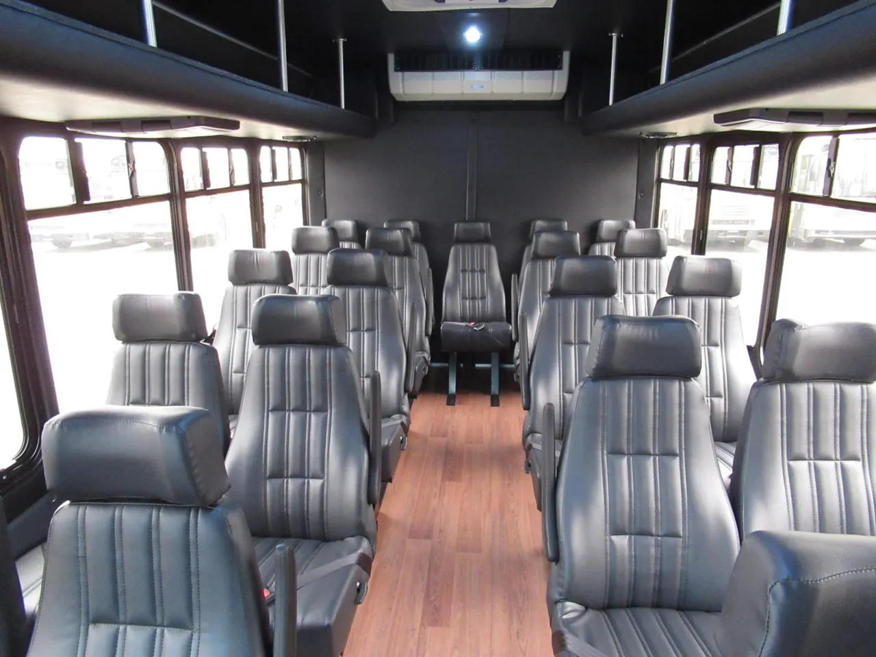 24 Passenger Ford E450 Executive VIP Shuttle Bus cabin view with wood-look flooring
