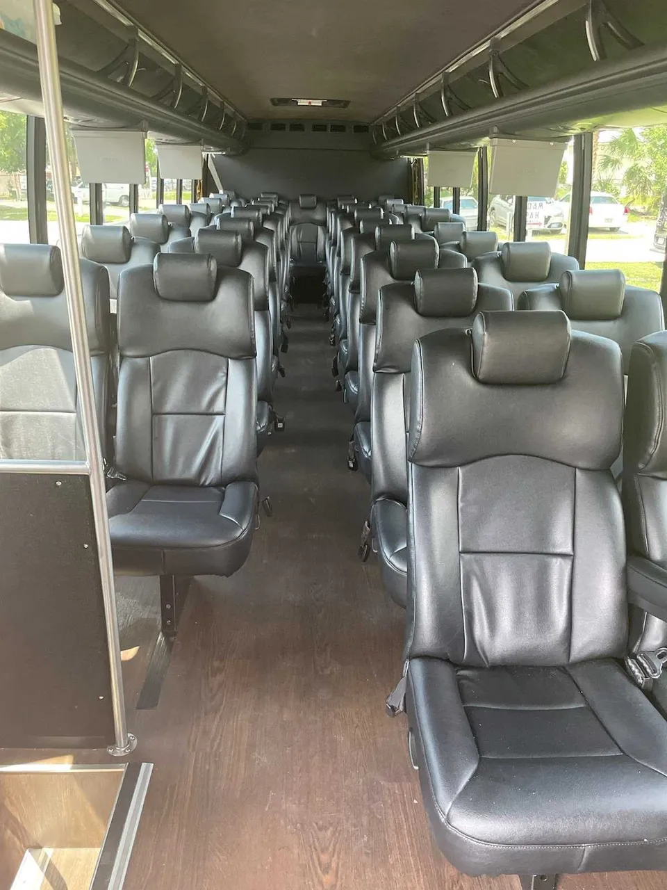 Freightliner Luxury Coach cabin view with TV screens and overhead parcel racks