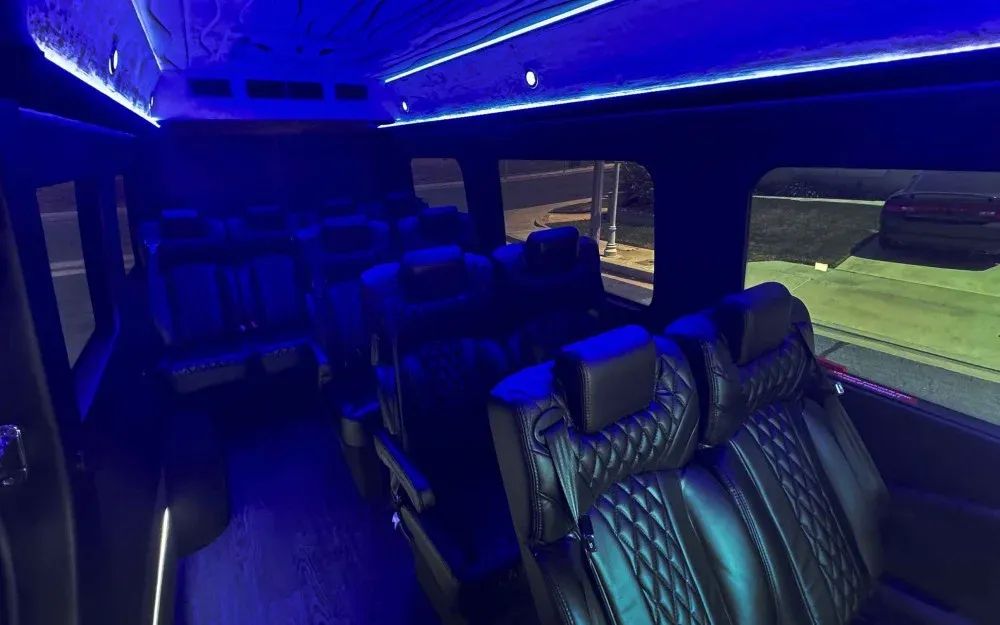 Gray Luxury Sprinter Shuttle Van cabin view with captain's chairs, LED accent lighting and LED ceiling lighting