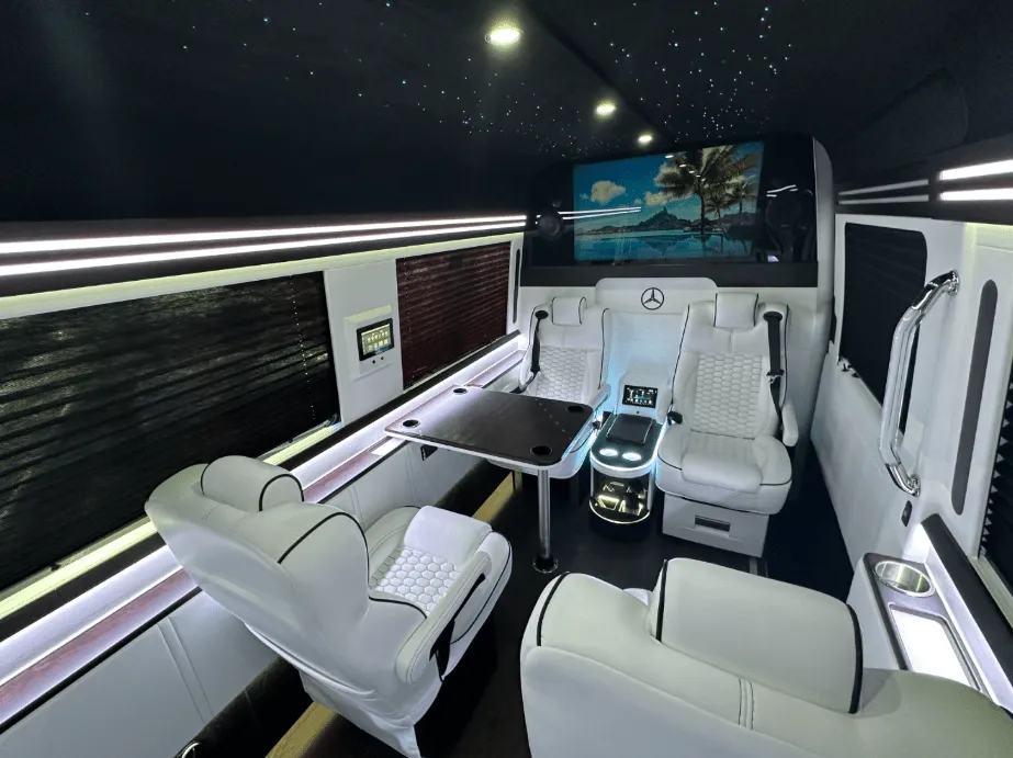Luxury Mercedes-Benz Sprinter cabin view, angle 3 with captain's chairs, passenger tables and window shades