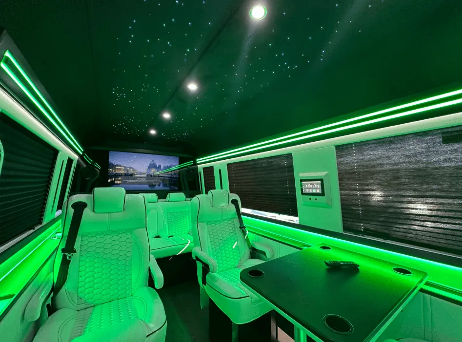 Luxury Mercedes-Benz Sprinter cabin view with captain's chairs, passenger tables and window shades