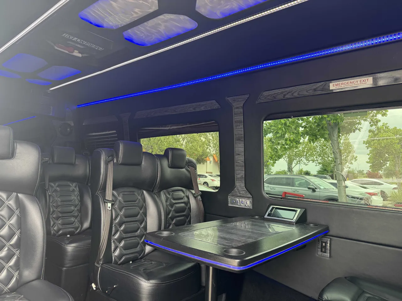 Mercedes-Benz Executive Sprinter cabin view with passenger tables, cup holders and LED accent lighting