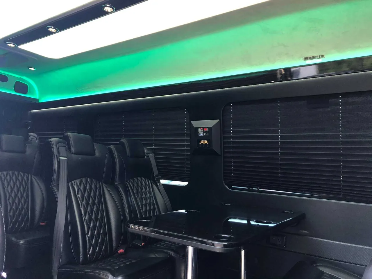 Mercedes-Benz Executive Sprinter cabin view with captain's chairs, passenger tables and window shades
