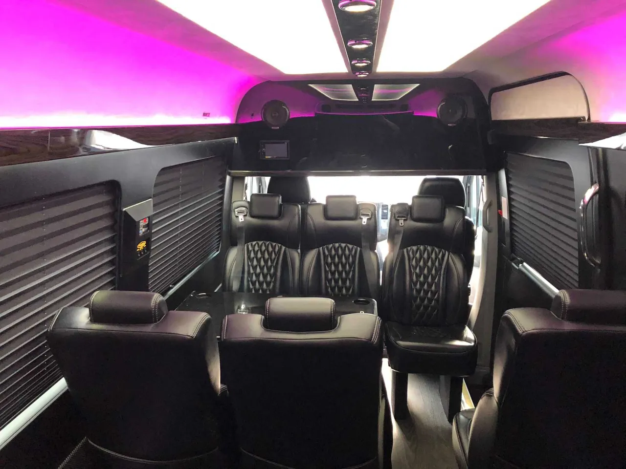 Mercedes-Benz Executive Sprinter cabin view with captain's chairs, window shades and LED ceiling lighting