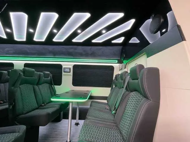 Mercedes-Benz Executive Sprinter cabin view, angle 2 with passenger tables, window shades and LED accent lighting