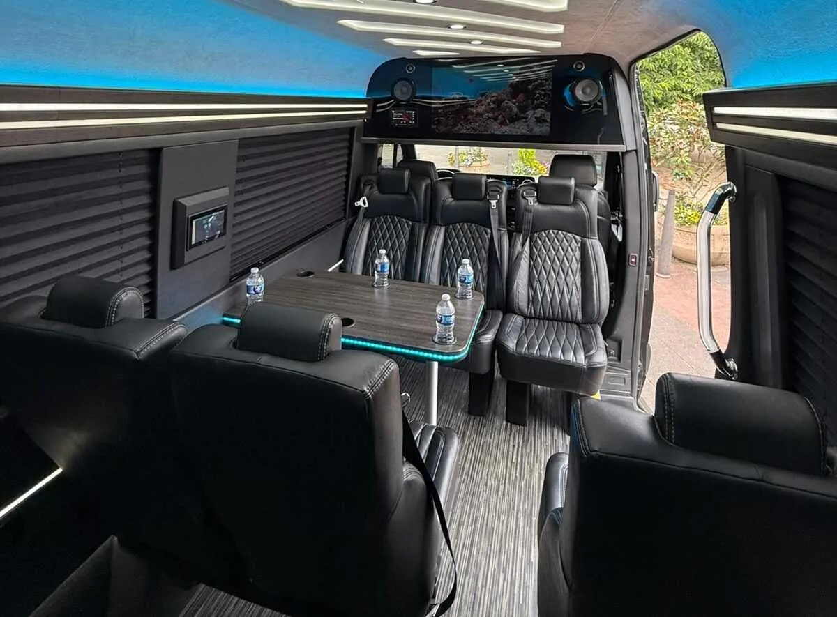 Mercedes-Benz Executive Sprinter cabin view, angle 2 with captain's chairs, passenger tables and window shades