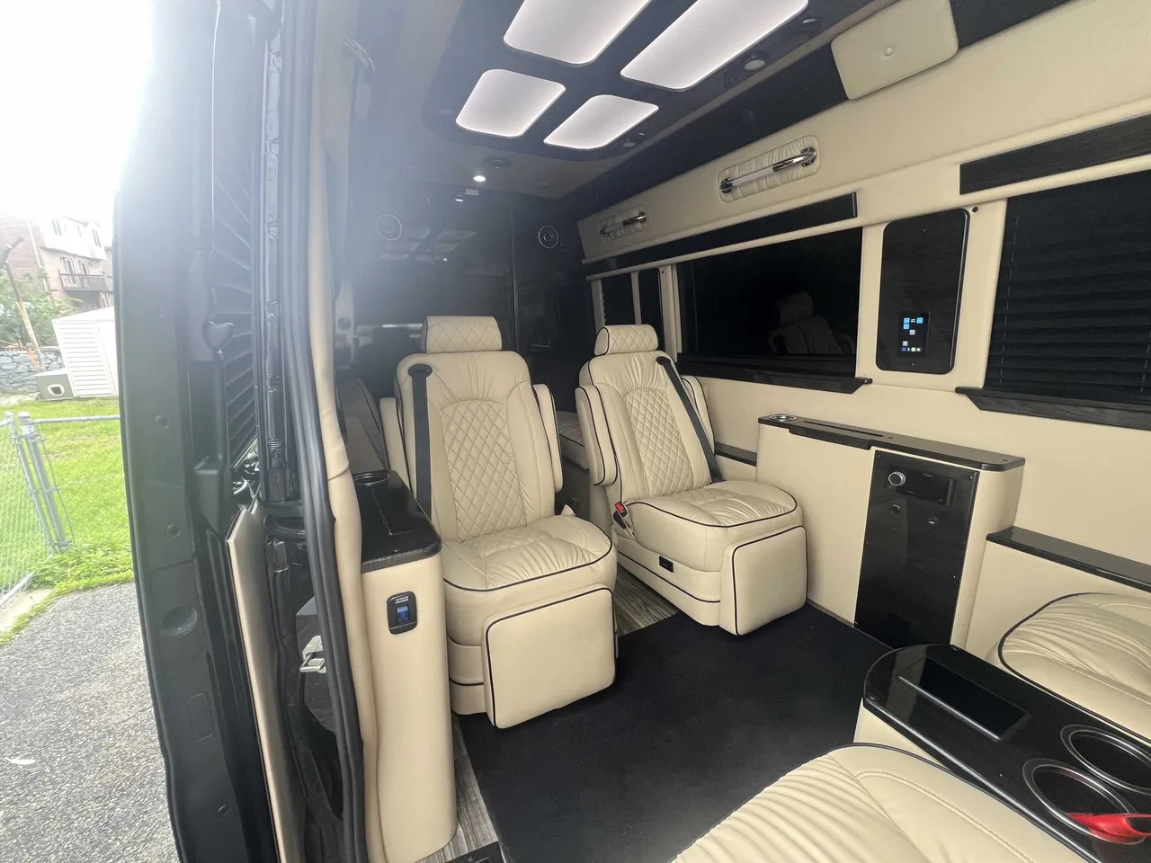 Mercedes-Benz Executive Sprinter cabin view with captain's chairs, window shades and LED ceiling lighting