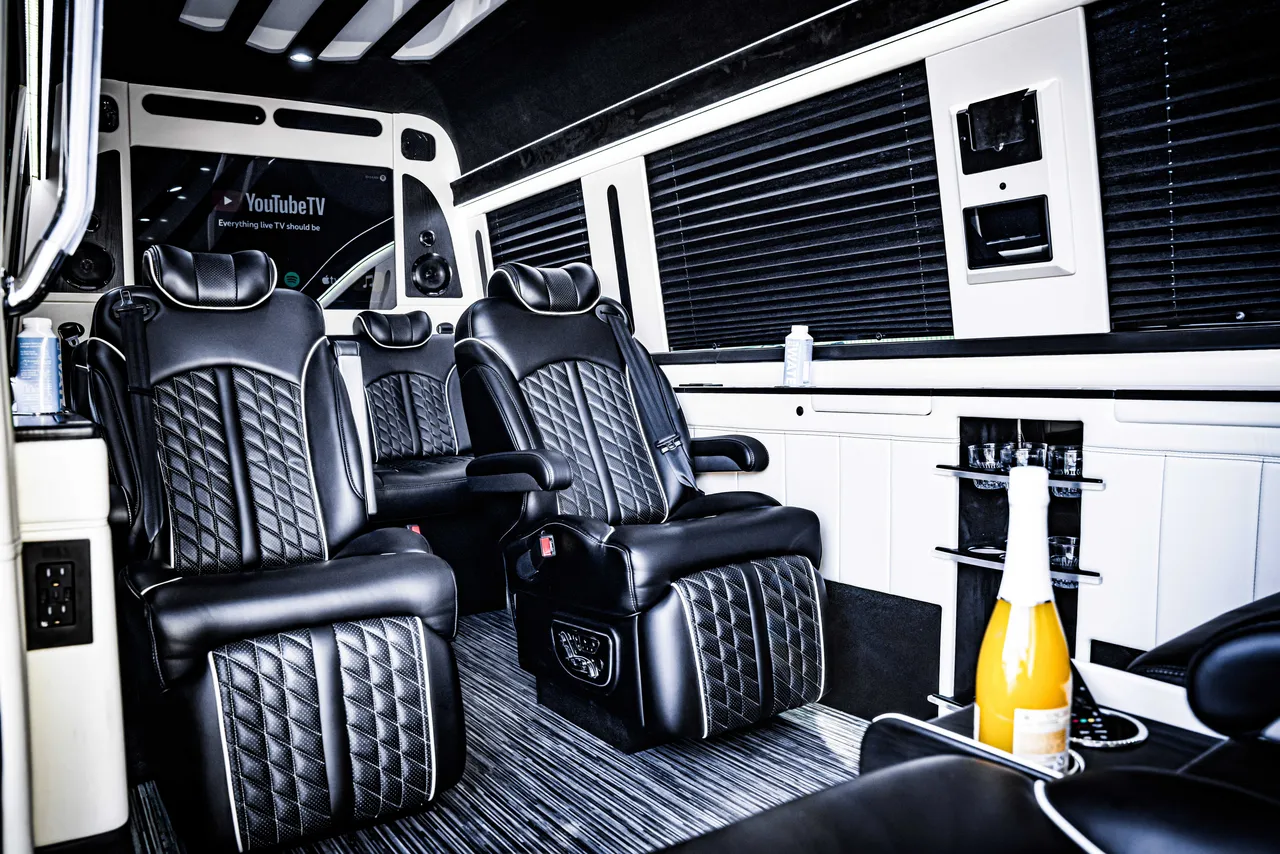 Mercedes-Benz Jet Sprinter cabin view with captain's chairs, window shades and TV screens