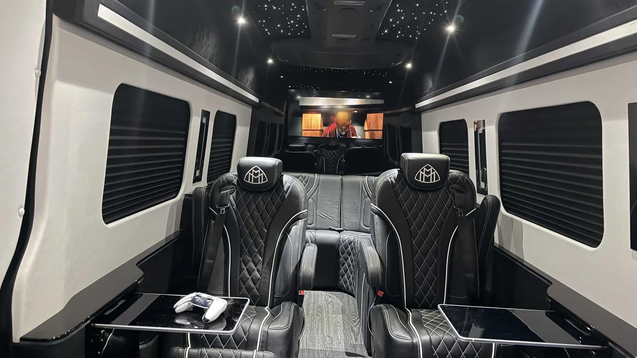 Mercedes-Benz Jet Sprinter Limousine cabin view with captain's chairs, passenger tables and starlight or fiber-optic ceiling