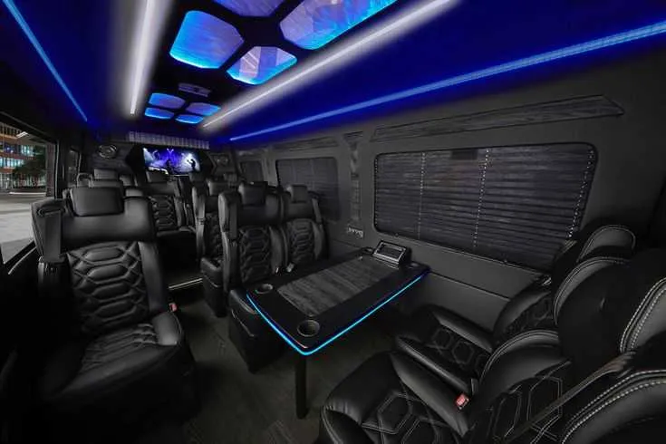 Mercedes-Benz Sprinter Executive Shuttle cabin view with captain's chairs, passenger tables and cup holders