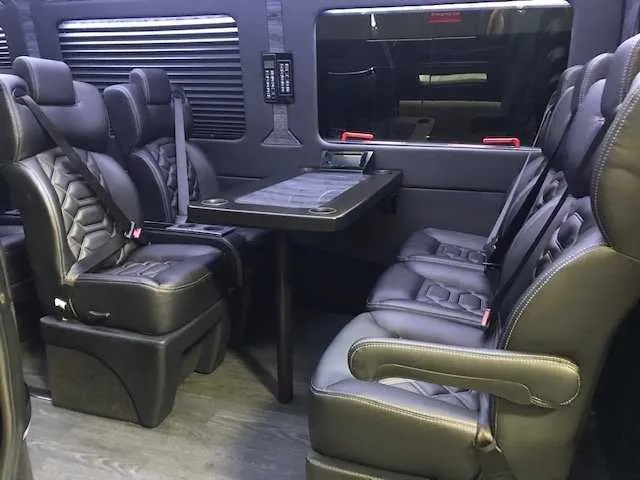 11 Passenger Mercedes-Benz Sprinter Luxury cabin view with captain's chairs, passenger tables and window shades