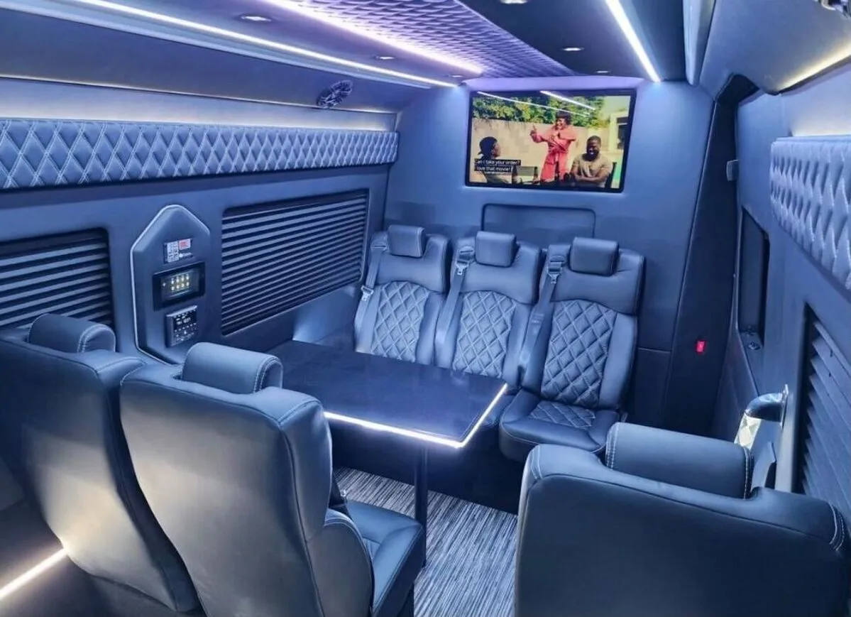 Mercedes-Benz Sprinter XL cabin view with captain's chairs, conference-style seating and passenger tables