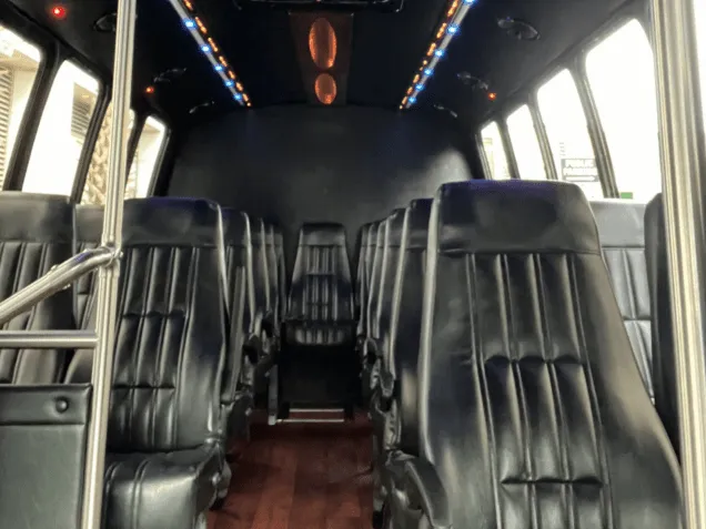 24 Passenger Mini Bus cabin view with LED accent lighting, wood-look flooring and grab handles and rails