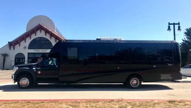 Black 28 Passenger Mini Coach exterior angle with tinted windows