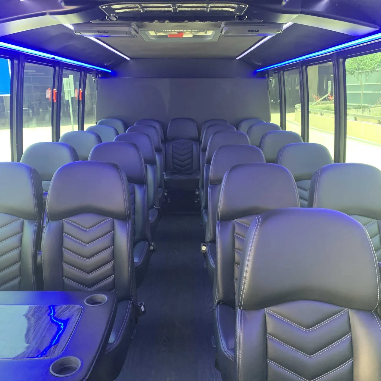 Ford F550 Executive Mini Bus cabin view with passenger tables, cup holders and LED accent lighting