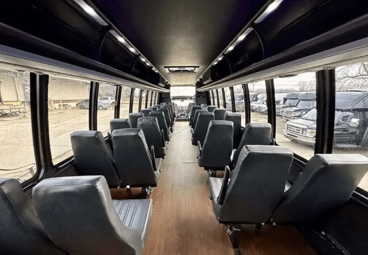 30 Passenger Mini Coach cabin view with wood-look flooring and overhead parcel racks