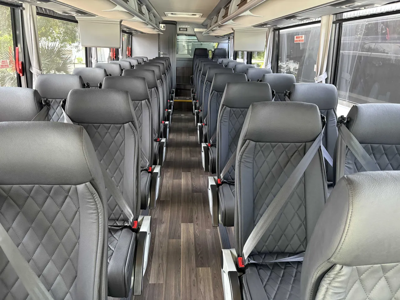 40 Passenger Mini Coach cabin view with airline-style seats, wood-look flooring and TV screens