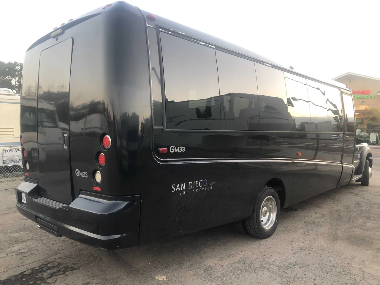 Black 21 Passenger Mini Coach exterior angle with tinted windows