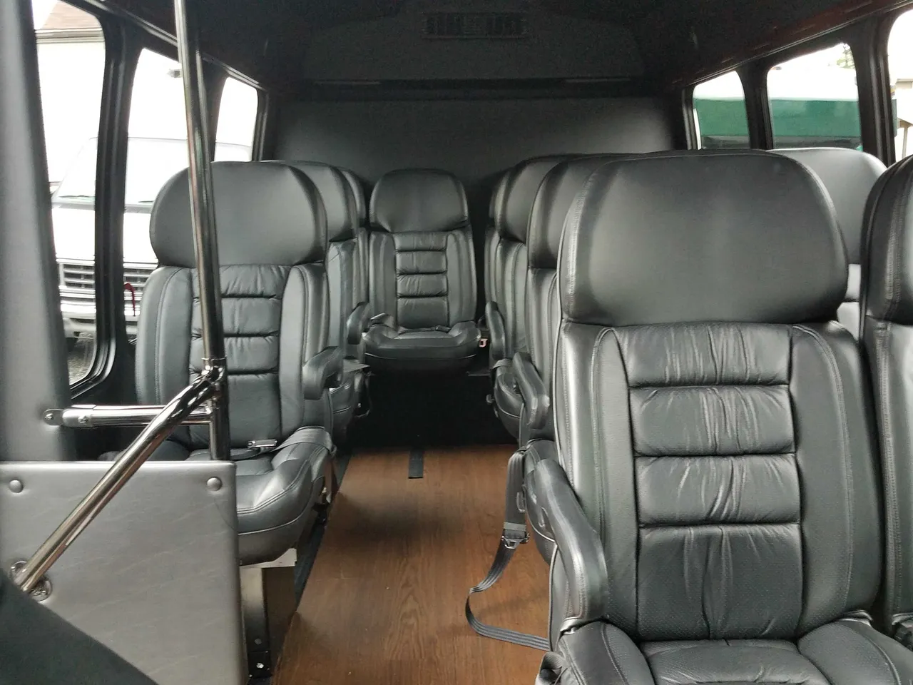 13 Passenger Mini Van 13 Passenger Mini Van cabin view with wood-look flooring and grab handles and rails