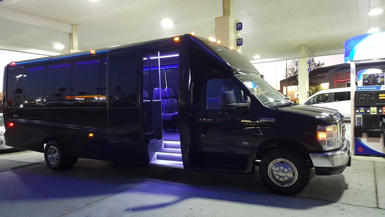Black 31 Passenger Mini Coach with tinted windows and LED accent lighting