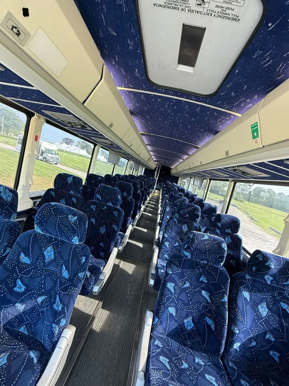 Motor Coach Luxury (Cloth Seats) cabin view, angle 6 with overhead parcel racks