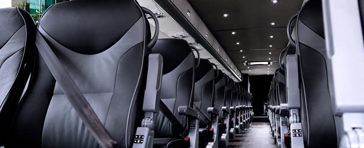 Motor Coach VIP (Leather Seats) cabin view with passenger seat belts and overhead parcel racks