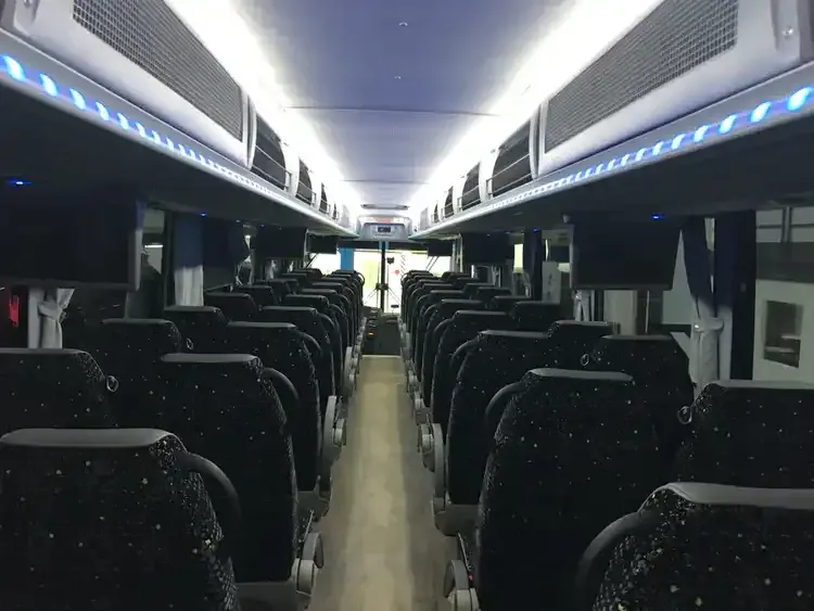 56 Passenger Motorcoach cabin view with LED accent lighting, LED ceiling lighting and overhead parcel racks