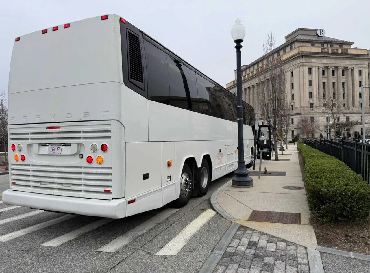 White 55 Passenger Motorcoach exterior angle, angle 3 with tinted windows