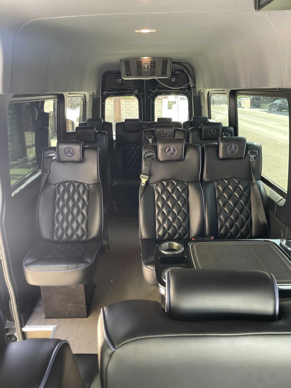 Sprinter Van cabin view, angle 3 with captain's chairs, passenger tables and cup holders