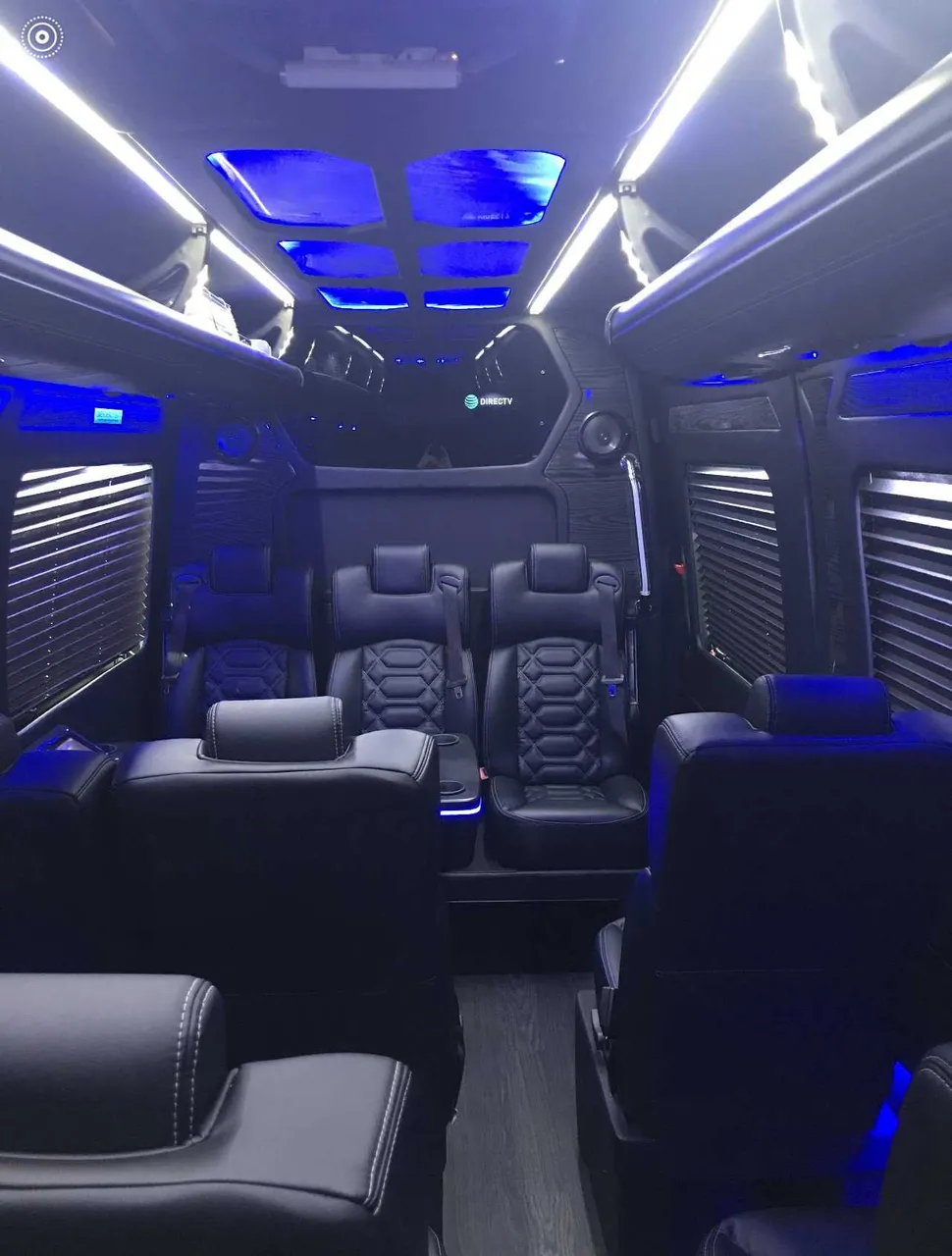 Sprinter VIP Van cabin view, angle 2 with captain's chairs, window shades and LED accent lighting